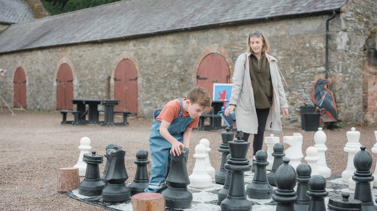 Family playing giant chess in summer